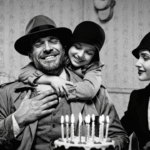 Black and white noir image of Jack Hammer with daughter Jackie Angel and wife Angela at a table with birthday cake