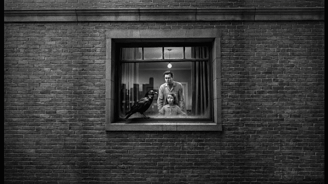 A jet black raven perches on a windowsill in front of a man and little girl. Noir