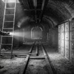 Basement arched brick corridor crisscrossed with heavy copper busbars as thick as a man’s wrist that stretches fifty yards into the sub-stratum with rows of gray steel filing cabinets that stand seven feet high, their drawer faces stamped with dates from nineteen-seventy-eight to nineteen-eighty-four.